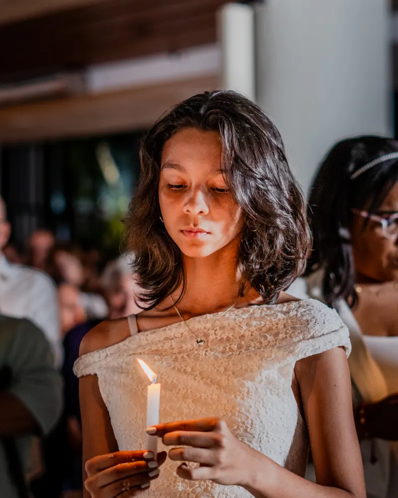 Una joven en oración con su vela encendida