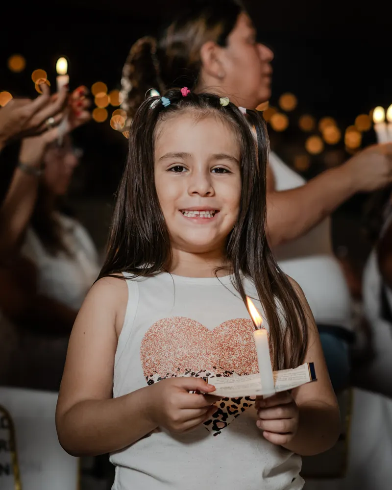 Una niña sonríe con su vela durante la vigilia
