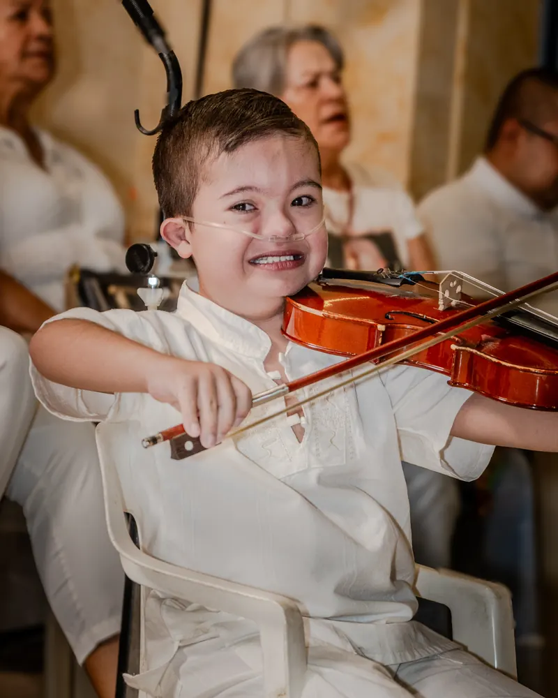 Un niño toca el violín durante la celebración